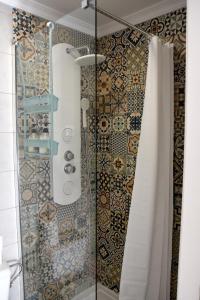 a shower in a bathroom with a shower curtain at Over the Beach in Monte Gordo