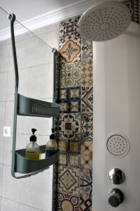 a bathroom with a shower with two soap dispensers at Over the Beach in Monte Gordo