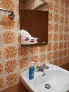 شاليه مزدانة في مكة المكرمة: حوض الحمام مع زجاجة مياه ومرآة