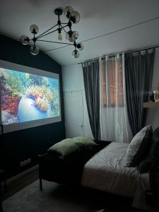 1 dormitorio con una gran pantalla de proyección y 1 cama en Maisonnette proche de Paris & Home cinema, en Bourg-la-Reine