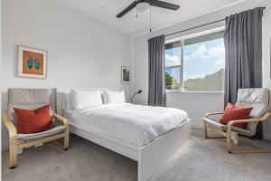 um quarto branco com uma cama grande e 2 cadeiras em Amazing Location Modern 2-Bed Townhome em Dallas