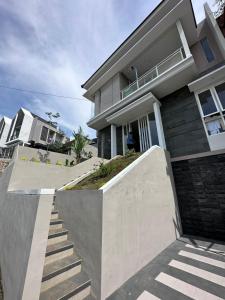 uma casa com uma escada em frente em Villa Sunrise F1 em Malang