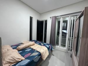 a bedroom with a bed and a large window at Villa Sunrise F1 in Malang +35 photos
