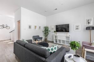uma sala de estar com dois sofás e uma televisão em Amazing Location Modern 2-Bed Townhome em Dallas