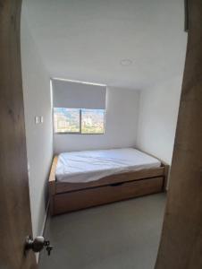 a small bed in a room with a window at Apartamento en Edificio Puerto paraiso en Bello Antioquia in Bello