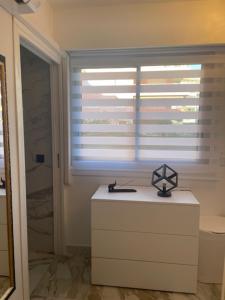 a bathroom with a white cabinet and a window at Andrea's holydays in Roquebrune-Cap-Martin