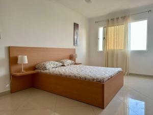 a bedroom with a bed and a lamp and a window at Cidade Velha - Cathedral and Sea view - 1Bdr Apart - 2 in Cidade Velha