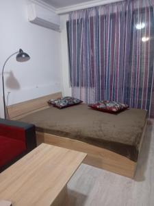 uma cama com duas almofadas num quarto em Studio Sarafovo em Burgas