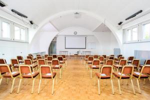 an empty room with chairs and a projection screen at Hotel La Longeraie in Morges