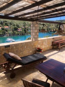 a patio with a table and bench and a view of a river at Villa More 3 Apartments A-10, A-11 and A-12 , 4-4-6 Beds in Bobovišća