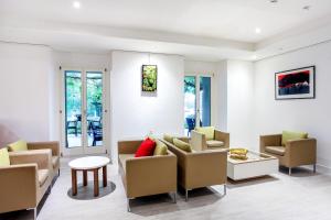 a living room with a couch and chairs and a table at Hotel La Longeraie in Morges