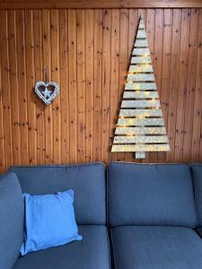 a christmas tree hanging on a wall with a couch at South Soul Cottage in Somme-Leuze