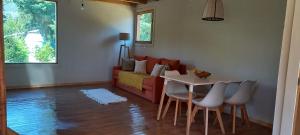 a living room with a couch and a table and chairs at Cabaña Zafiro del Piltri in Golondrinas
