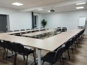 une salle de classe avec rangées de tables et de chaises dans l'établissement Brit Hotel L'Arrivée Guingamp, à Guingamp