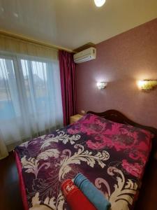 1 dormitorio con 1 cama con manta morada y blanca en Квартира возле Радмир ул.Чернивецкая 5в, en Járkov