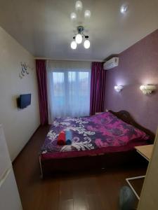 1 dormitorio con 1 cama con edredón morado en Квартира возле Радмир ул.Чернивецкая 5в, en Járkov