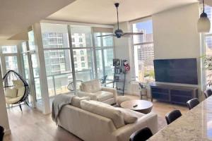 a living room with a couch and a flat screen tv at Luxe 1BR plus Den near Little Italy Gem in San Diego