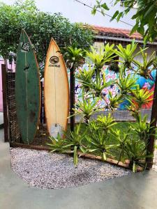 two surfboards are leaned up against a fence at Suíte Colorida em Cabo Frio in Cabo Frio