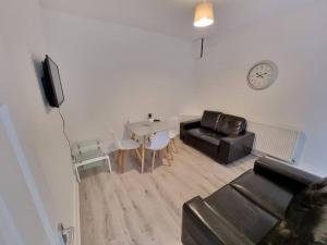 uma sala de estar com um sofá e uma mesa em Peaceful 4 Bedroom House with Free Parking em Liverpool