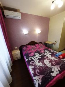 1 dormitorio con 1 cama con manta morada y blanca en Квартира возле Радмир ул.Чернивецкая 5в, en Járkov