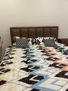 ein Bett mit einer schwarz-weißen Steppdecke darauf in der Unterkunft Kopaonik-Residence Hill Repnica A71 in Čajetina + 40 Fotos