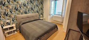 a living room with a bed and a tv at Affittacamere Le Vele in Genoa