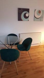 twee groene stoelen en een glazen tafel in een kamer bij Blue Door Cottage in Meanwood