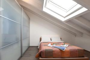 een slaapkamer met een bed en een dakraam bij Elegant Lugano Lake View - Happy Rentals in Caslano