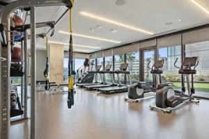 a gym with a row of treadmills and ellipticals at 2BR Lux Highrise + Austin + Vibrant Rainey St in Austin