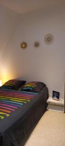 Un dormitorio con una cama con una manta de colores. en Saint Georges, 