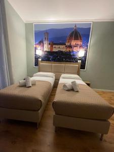 two beds in a room with a view of a city at Titta & Ruffo in Pisa