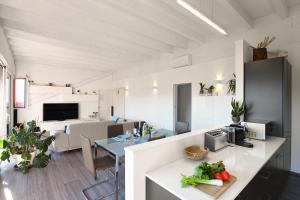 una cucina e un soggiorno con tavolo e verdure su un bancone di Elegant Lugano Lake View - Happy Rentals a Caslano