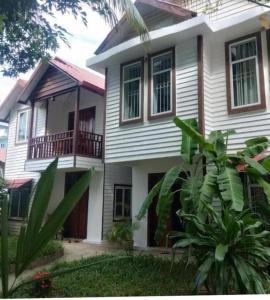 a white house with a porch and a balcony at Manoha Villa in Sihanoukville