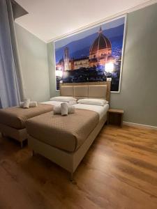 1 Schlafzimmer mit 2 Betten und einem Bild eines Gebäudes in der Unterkunft Titta & Ruffo in Pisa