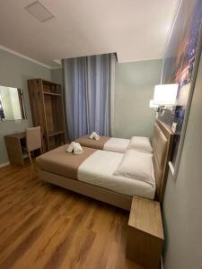 ein Schlafzimmer mit einem großen Bett in einem Zimmer in der Unterkunft Titta & Ruffo in Pisa
