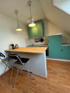 a kitchen with green cabinets and a table and chairs at JonnysSleepOver in Osnabrück