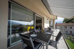 een zwarte eettafel en stoelen op een balkon bij Casa Marianna in Gravedona