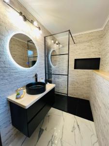 Un baño con un lavabo negro y un espejo. en Central Studio 28, en Sinaia