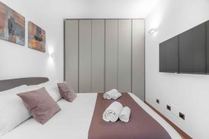 een slaapkamer met een wit bed en 2 handdoeken bij Sebenico 10 in Milaan