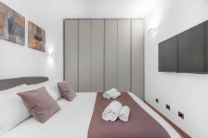 a bedroom with a white bed with two towels on it at Sebenico 10 in Milan
