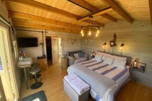 a bedroom with a large bed in a wooden room at Driftwood Retreat with Hot tub in Week Saint Mary