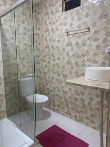 a bathroom with a toilet and a glass shower at Pousada D'casa in Barreirinhas +16 photos