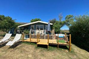 a large deck with two chairs and a house at Driftwood Retreat with Hot tub in Week Saint Mary