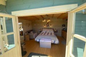 a bedroom with a large bed in a room at Driftwood Retreat with Hot tub in Week Saint Mary