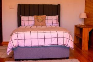 een slaapkamer met een bed met een roze dekbed bij Cozy Haven in East London