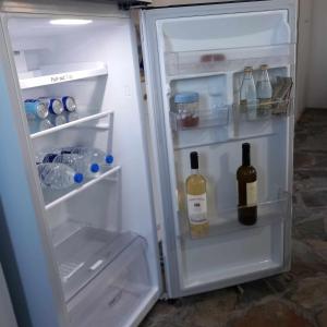 een open koelkast met twee flessen wijn bij Serenity Maisonnette in Otziás