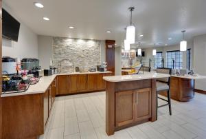 cocina grande con armarios de madera y pared de piedra en Staybridge Suites - San Antonio - Schertz, an IHG Hotel, en Schertz