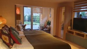 a bedroom with a large bed with a flat screen tv at Prosecco Apartman in Balatonfüred