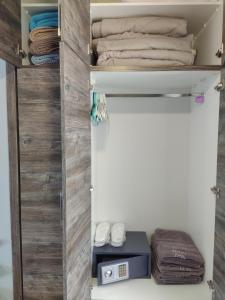 a closet with wooden sliding doors and towels at Celeste Deluxe Apartments in Skala Potamias