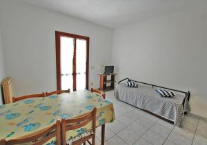 Zimmer mit einem Tisch, einem Bett und einem Fenster in der Unterkunft CASA CECILIA in Marina di Campo